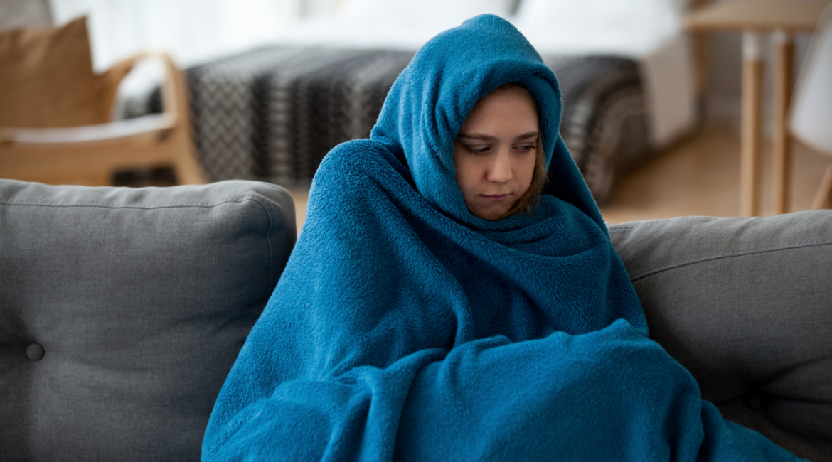 mujer en el sofá tapada con una manta